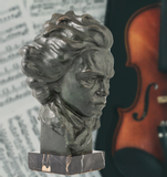 a statue of a man with a violin in the background